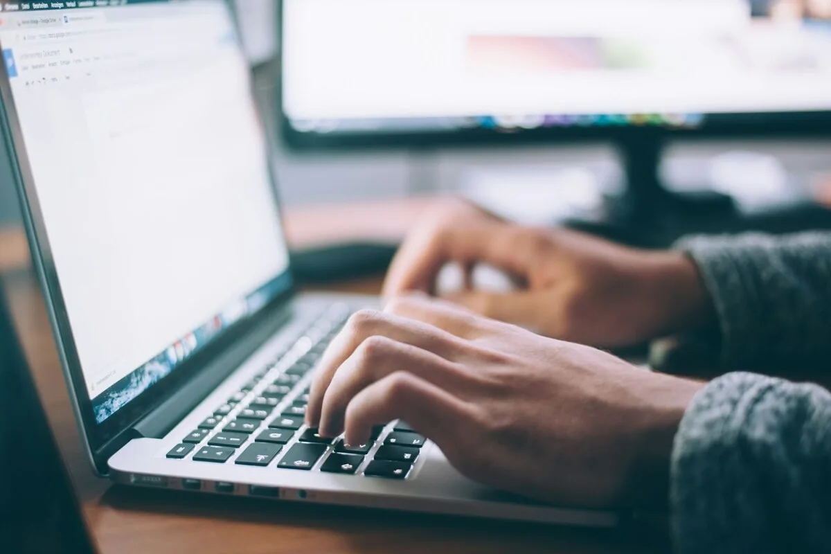 Promoteur d'événements examinant des campagnes email personnalisées avec l'IA sur son ordinateur